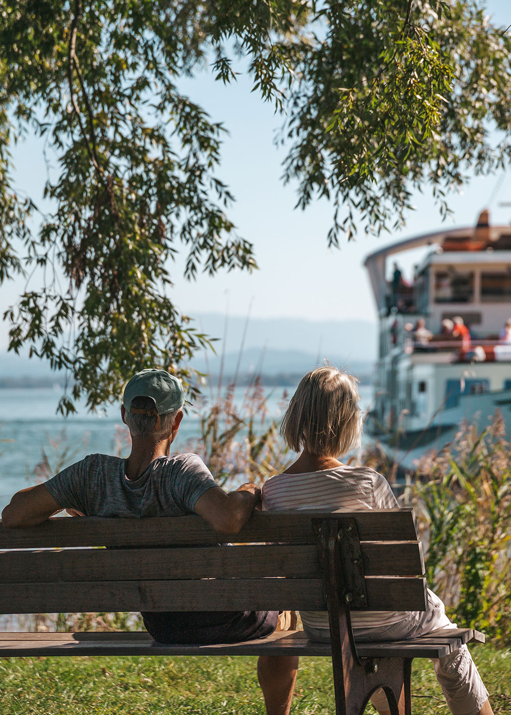 Personen auf Sitzbank am Chiemsee