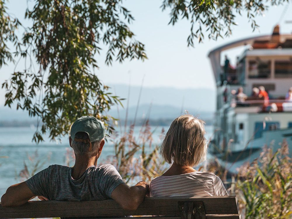 Personen auf Sitzbank am Chiemsee